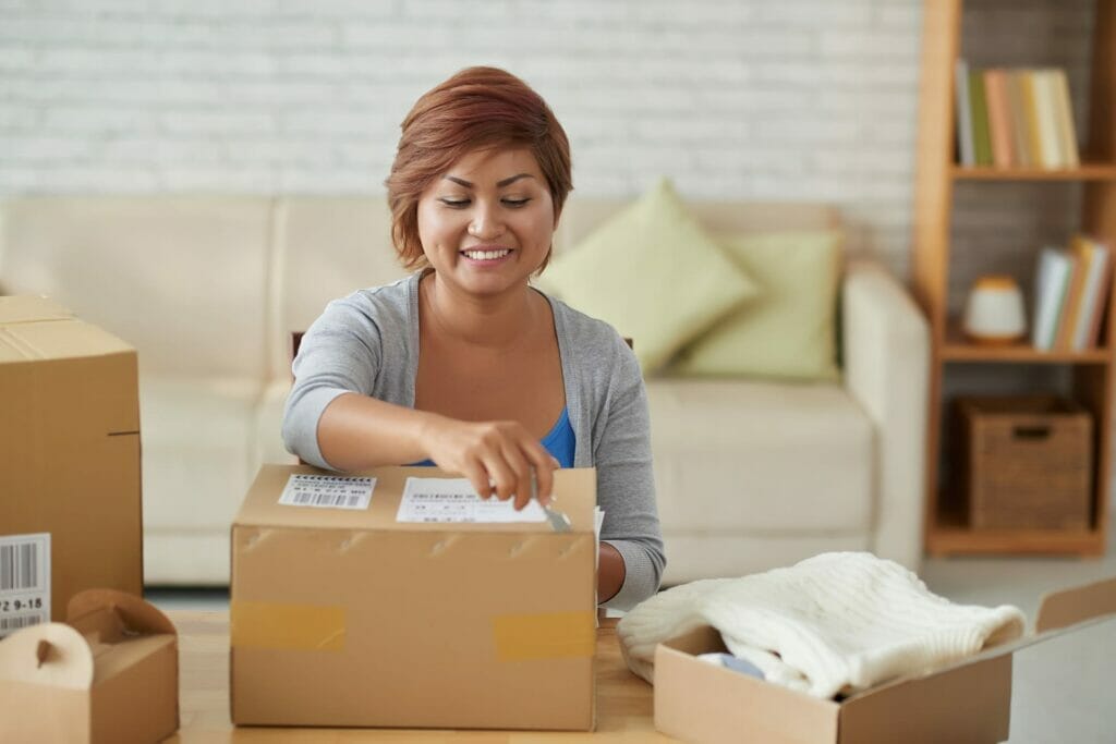 A woman, who is a business owner or consultant, is opening a box in her living room.