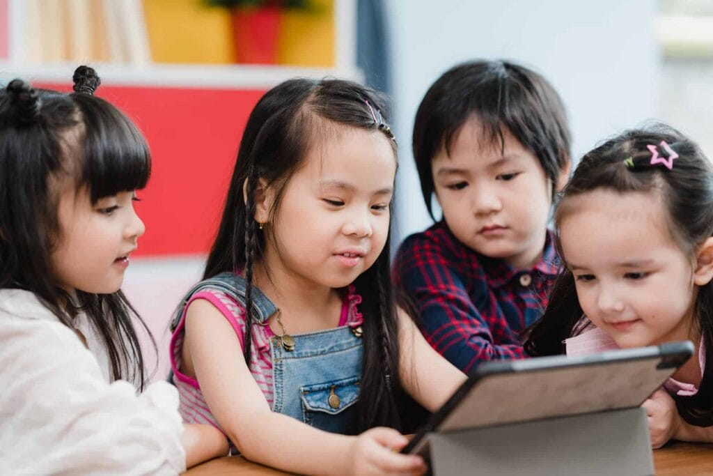 A group of children looking at a tablet computer.